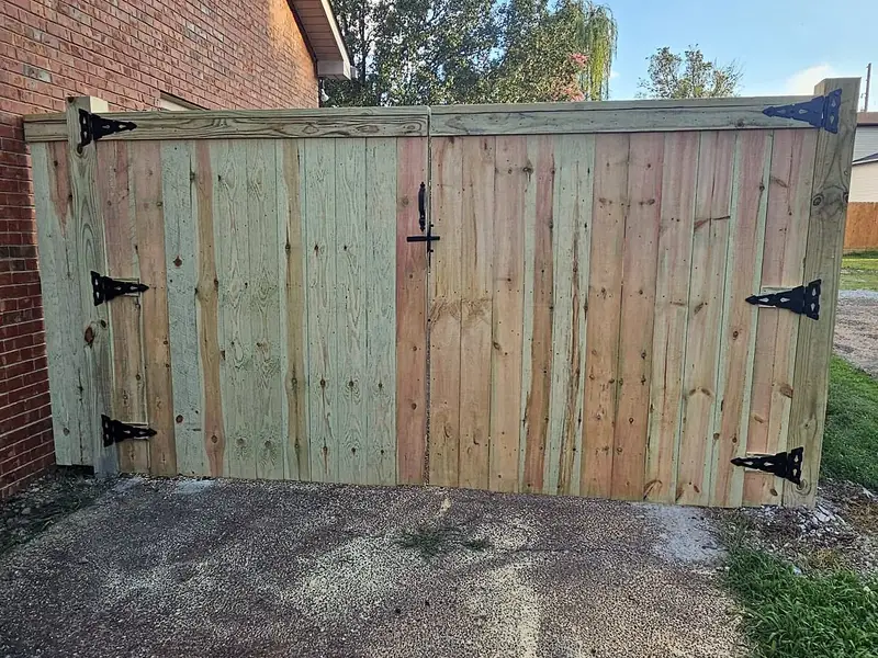 Double wood drive gate with black strap hinges