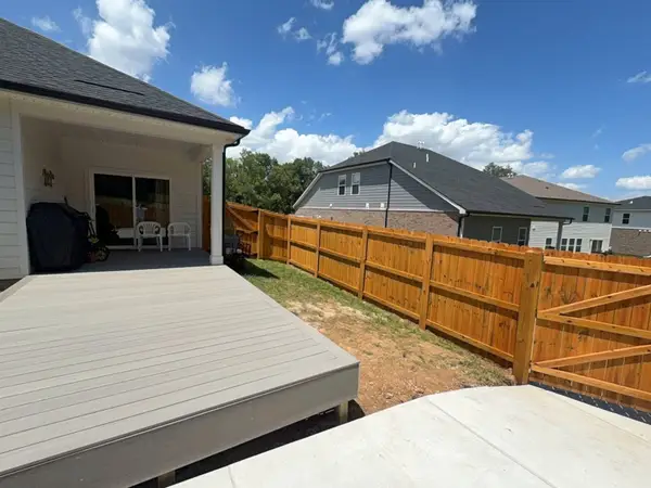 Stained privacy fence around a backyard with a composite deck